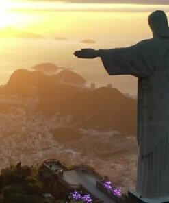 Vista aérea do Cristo Redentor com o por do sol ao fundo, representando os principais pontos turísticos do Rio de Janeiro, oferecido no City Tour com saída de Cabo Frio pela agência Costa do Sol Tour.